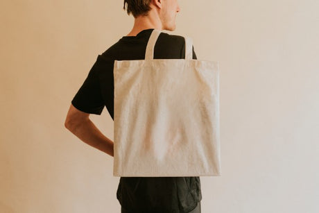 A man carrying a tote bag.
