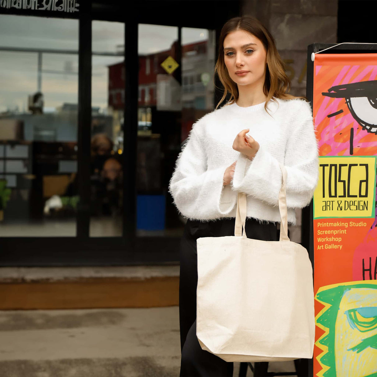 Woman holding the Recycled Trader's Canvas Tote in a casual lifestyle setting, highlighting the bag's spacious design and eco-conscious appeal.